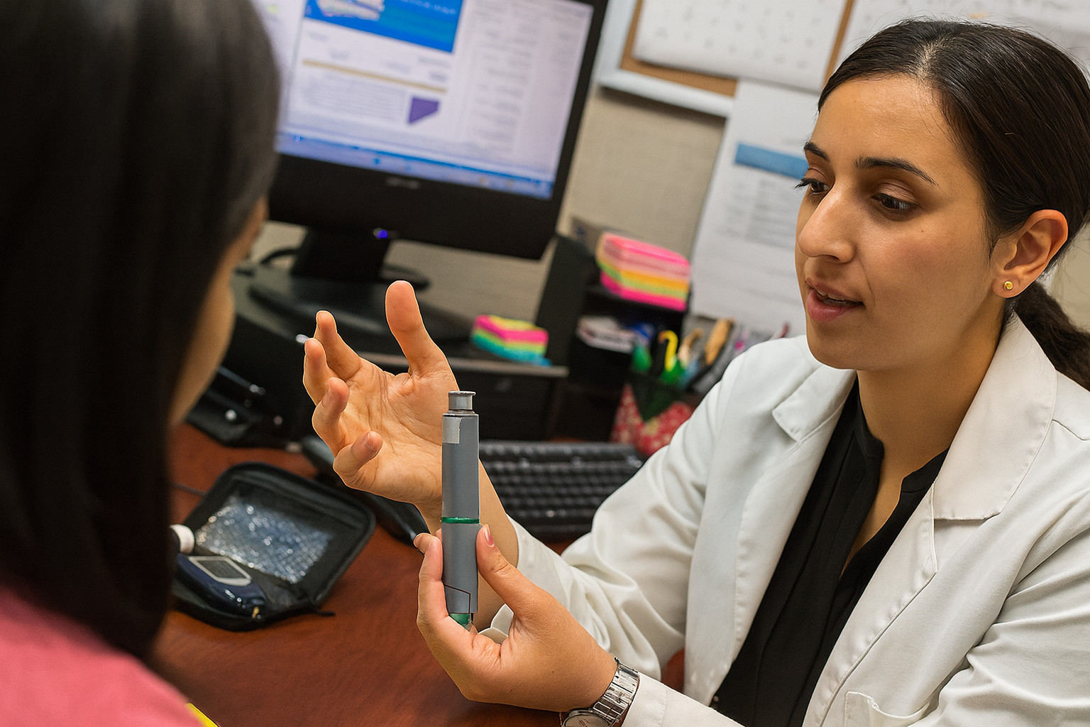 Pharmacist reviewing documents with a colleague in a professional setting