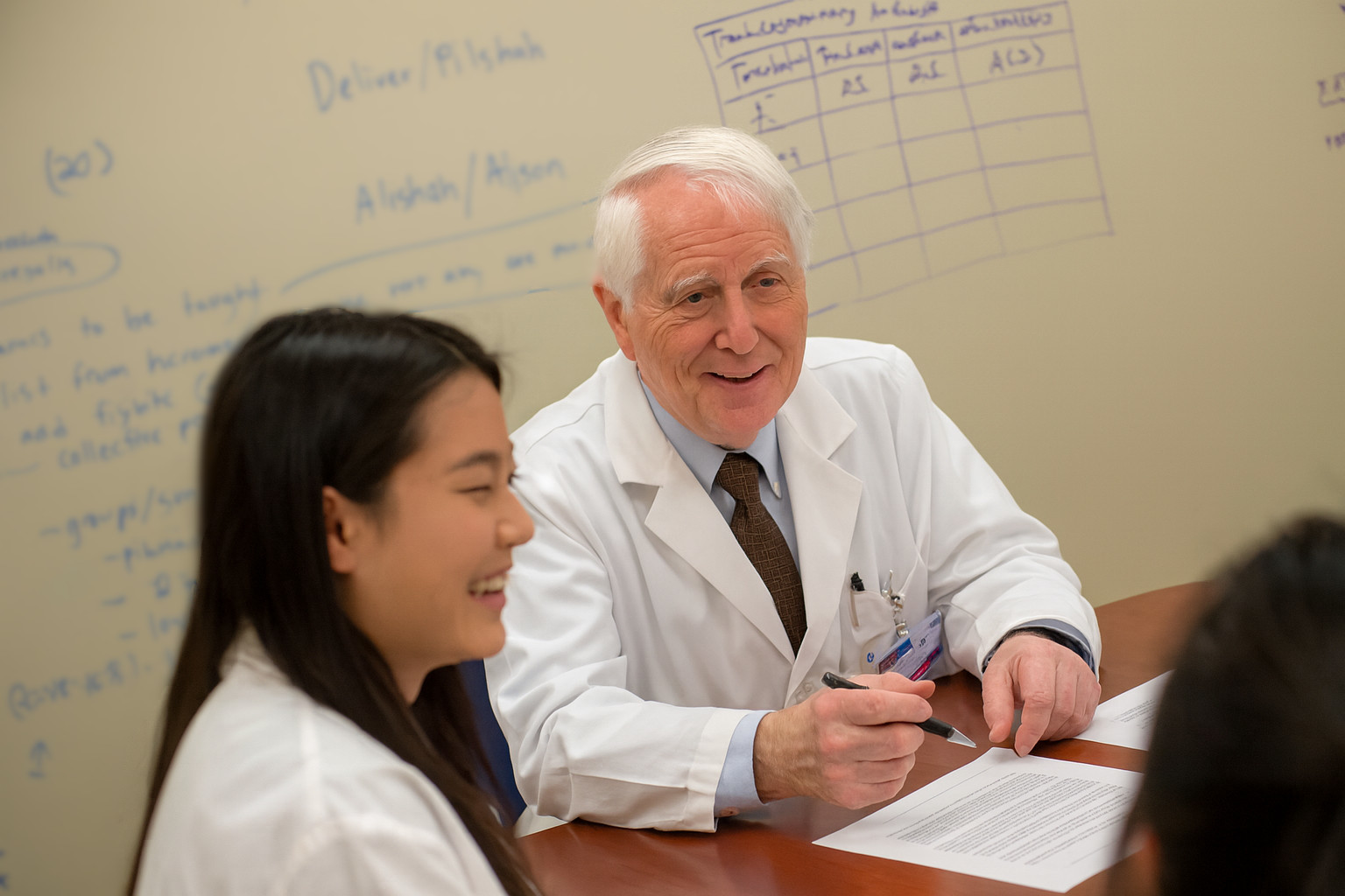 A diverse group of professional pharmacists collaborating around a table.